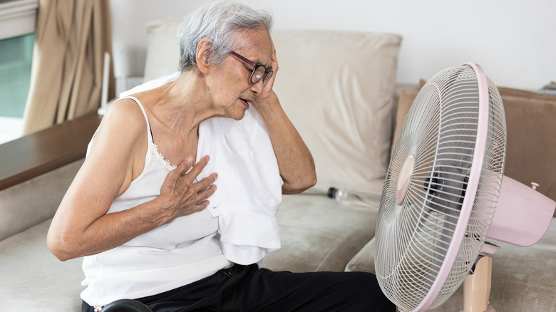 Overheated woman in front of fan