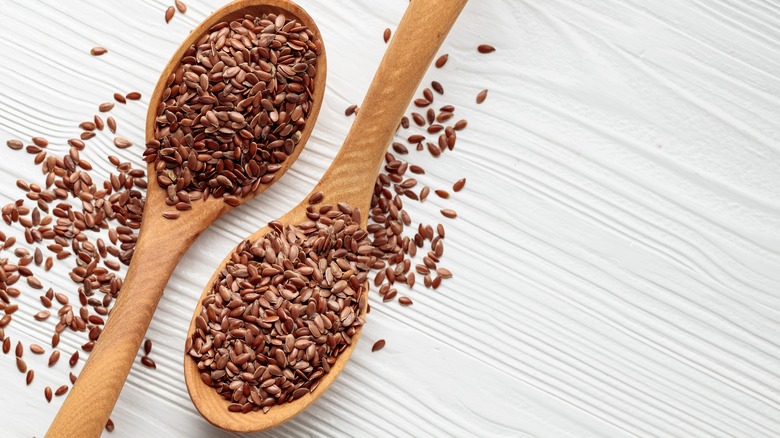 two wooden spoons with flaxseeds