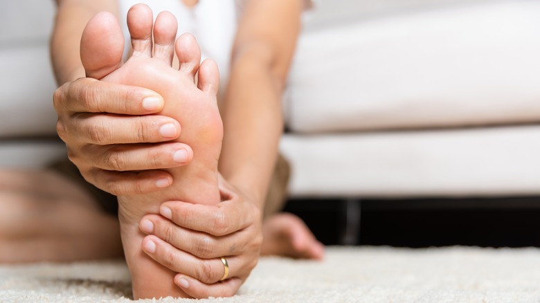 woman massaging foot