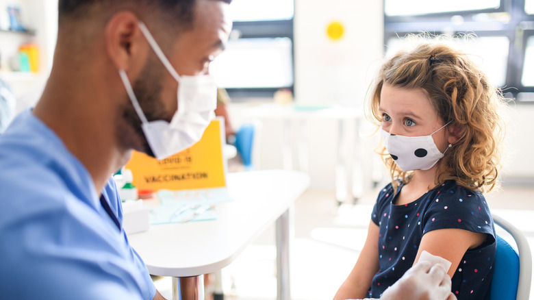 nurse cleaning child's arm for vaccination