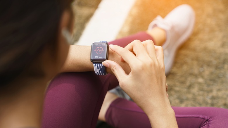 woman checking heart rate on watch
