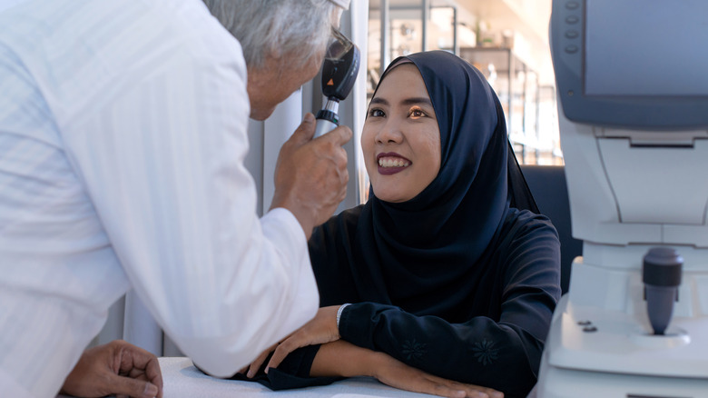 Eye doctor shining light into patient's eye