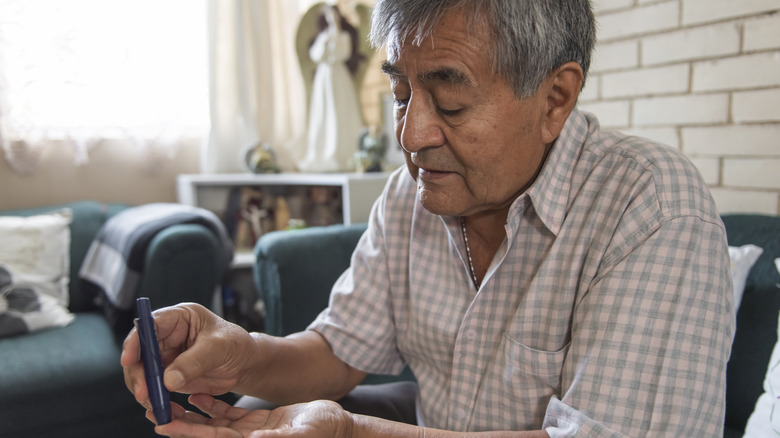 Older man checking blood sugar