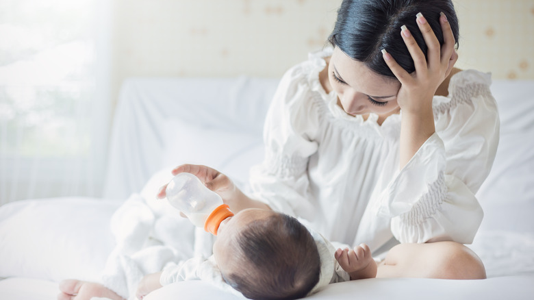 parent feeding baby a bottle