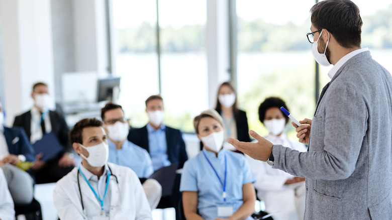 Masked teacher conducting medical training course