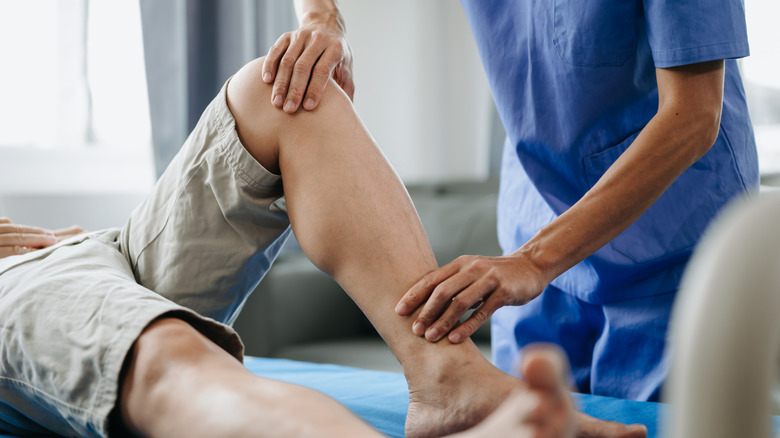 therapist working with a patient on leg recovery