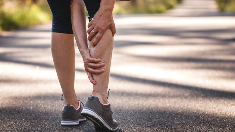 woman stretching outside in pain