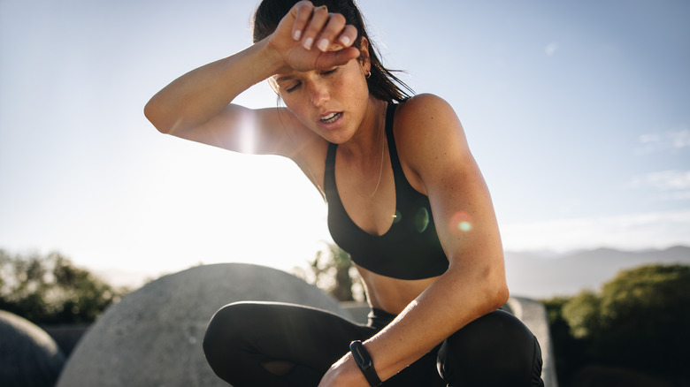 exhausted young woman resting after workout