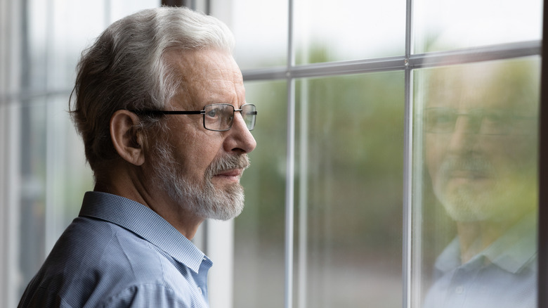 worried senior staring out of window