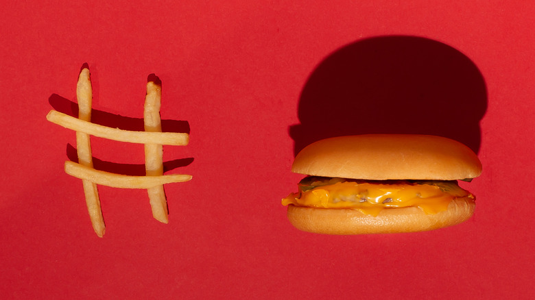 hashtag made of french fries and a cheeseburger against all red background 