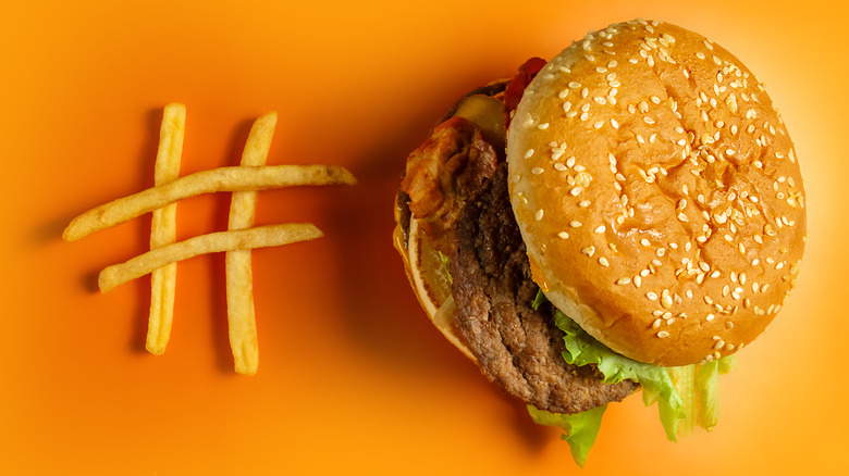 Hashtag made of fries next to a McDonald's Big Mac on yellow background
