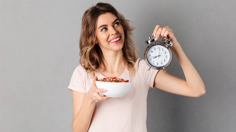 woman holding food and clock