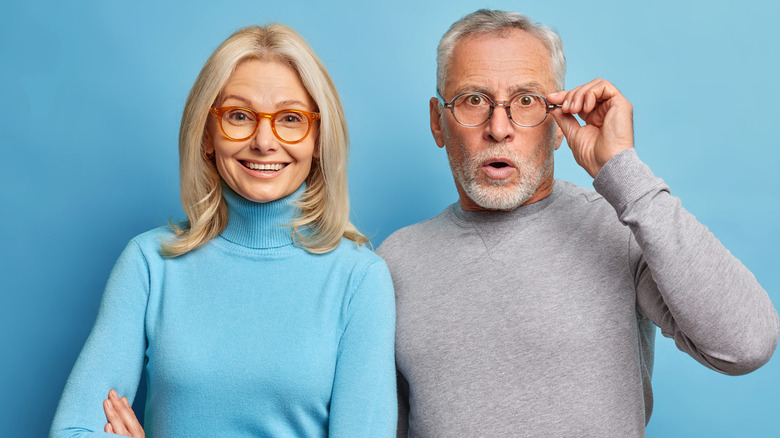 woman smiling, next to man looking surprised