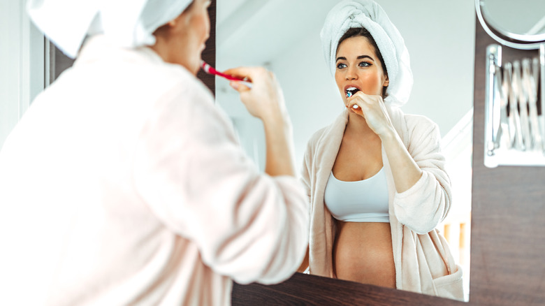 Pregnant woman brushes her teeth 