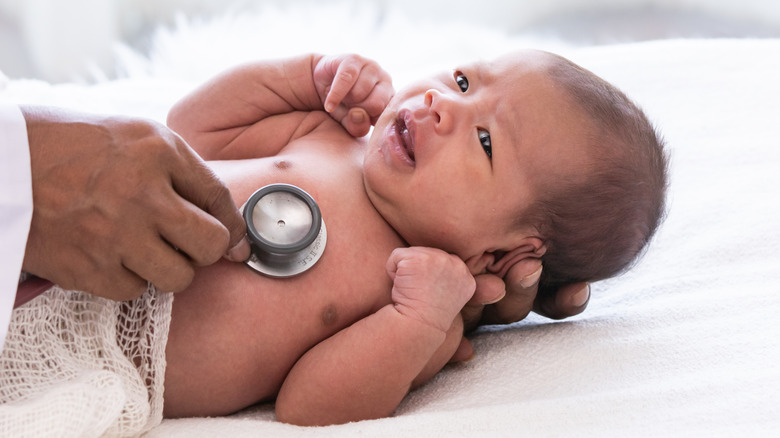 Doctor examining newborn