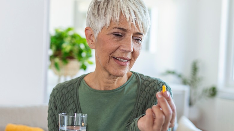 mature woman looking at pill