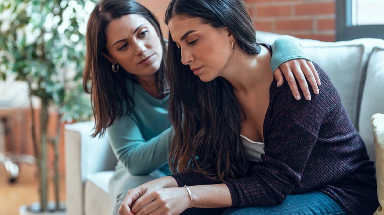 friend with arm around sad woman