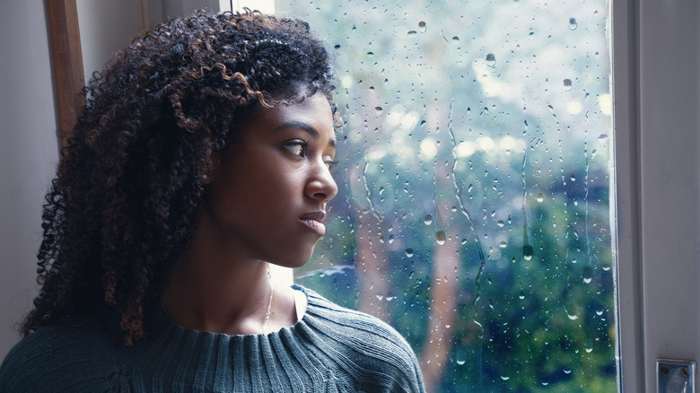 Black woman sad looking out window