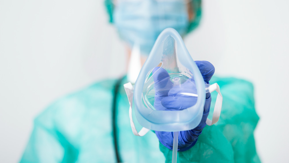 health care worker holds oxygen mask