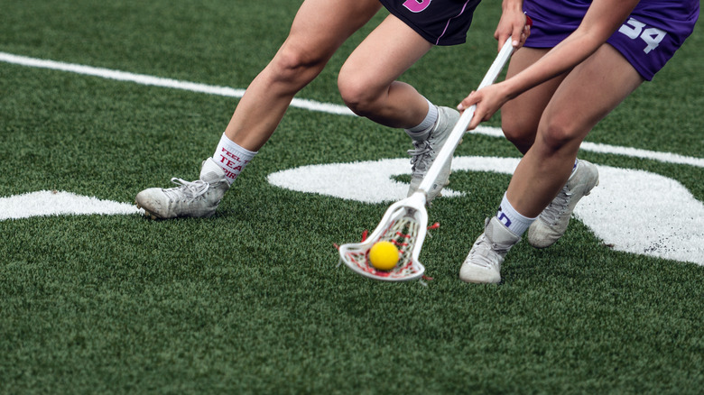 Lacrosse players scooping ball 