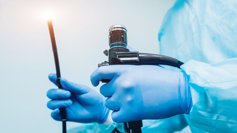 Close up of a doctor holding an endoscope in gloved hands