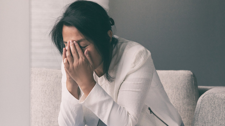 Stressed woman sits on a couch 