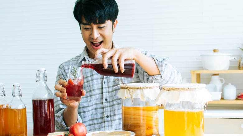 Man pouring kombucha into a glass