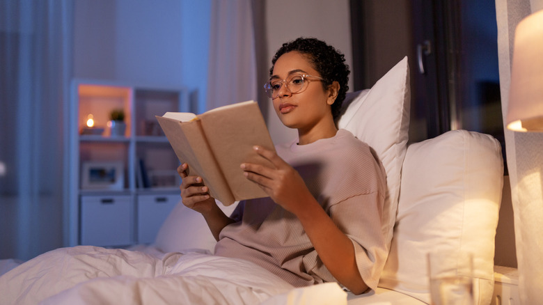 Woman in glasses reading in bed