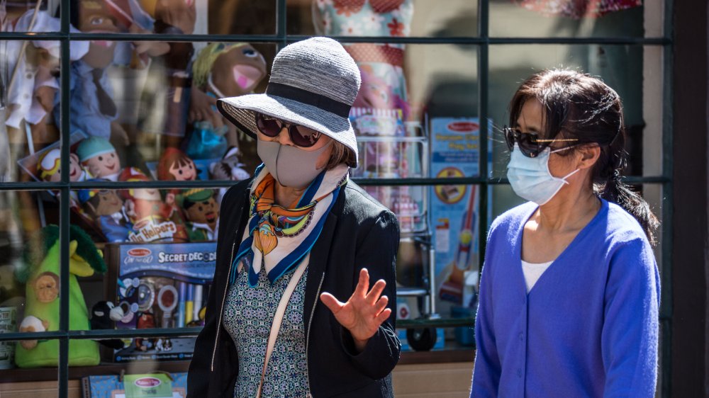 Women stroll by shops in California