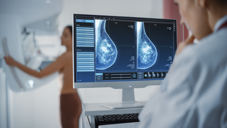 A doctor examines a woman's mammogram 
