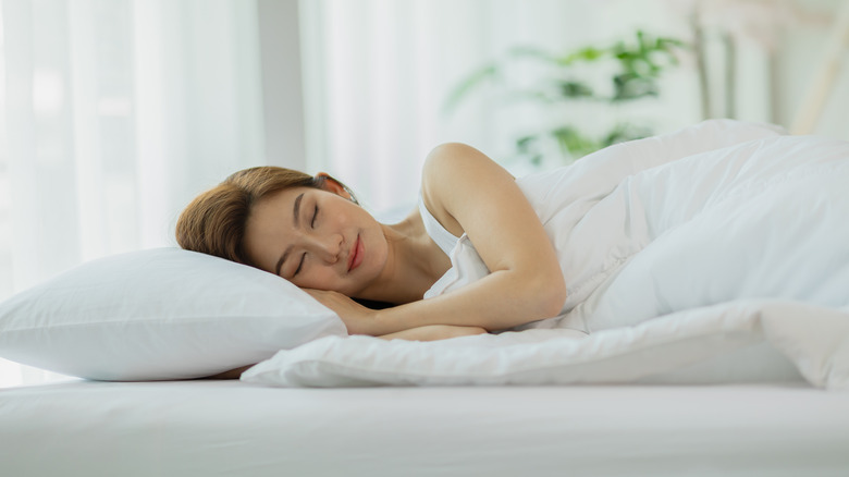 A woman sleeps peacefully in bed