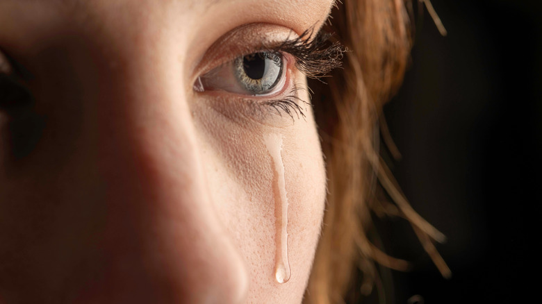 Close up on single tear falling down woman's cheek