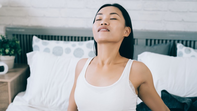 Woman leaning back on bed