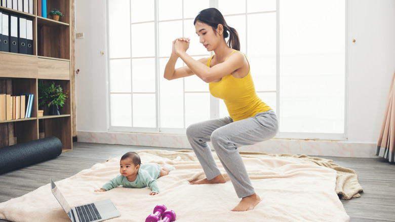 A woman squats at home