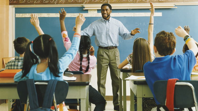 man teaching schoolchildren