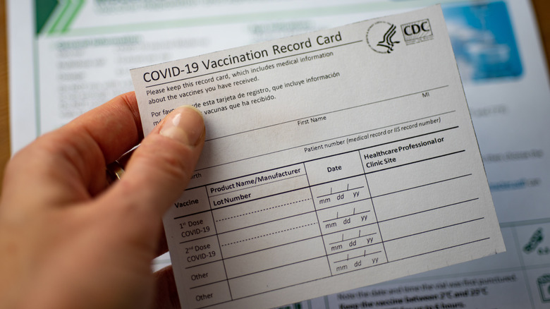 Hand holding a CDC COVID-19 Vaccination Record Card