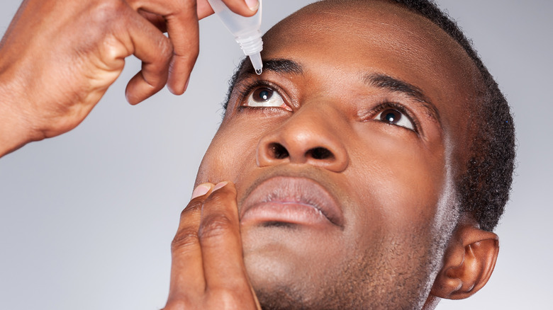 Man using eye drops