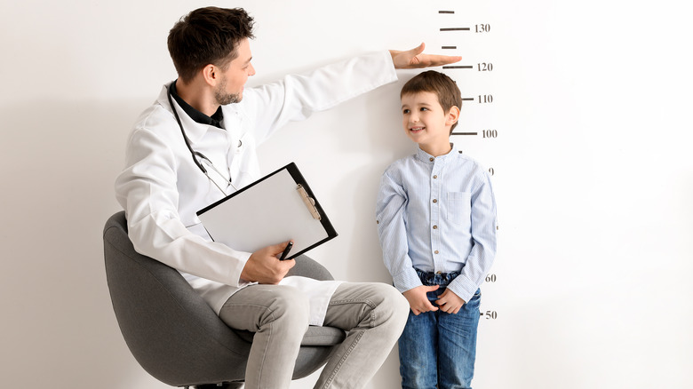 Doctor measuring height of child