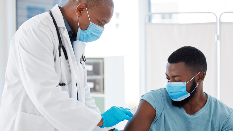 Masked man receiving vaccine