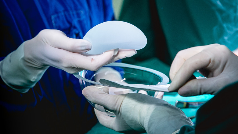 doctor holding breast implant