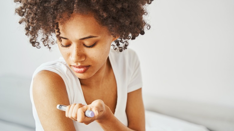 a woman taking an insulin shot