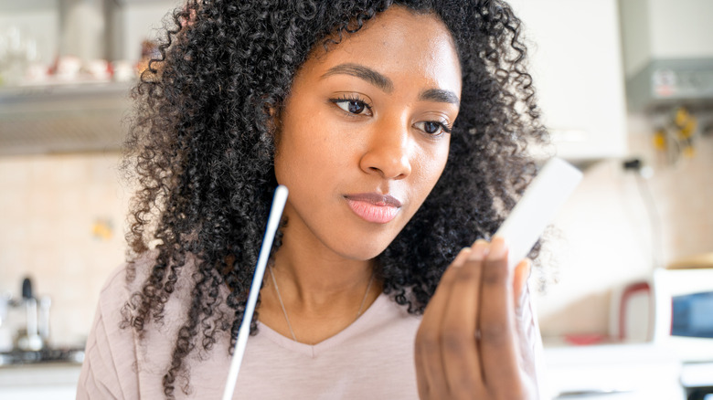 Young woman using COVID home test