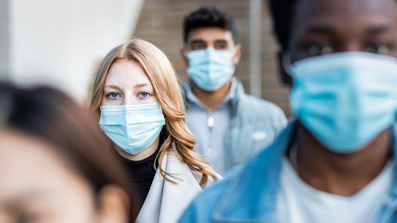 Masked people walking outside