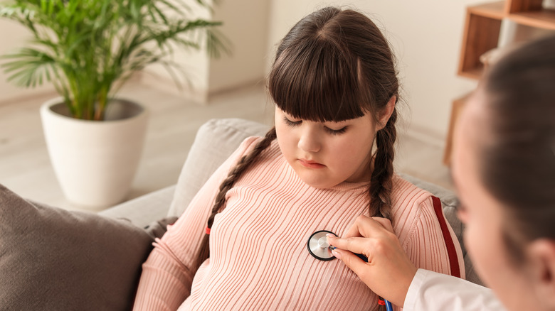 Doctor using stethoscope on child