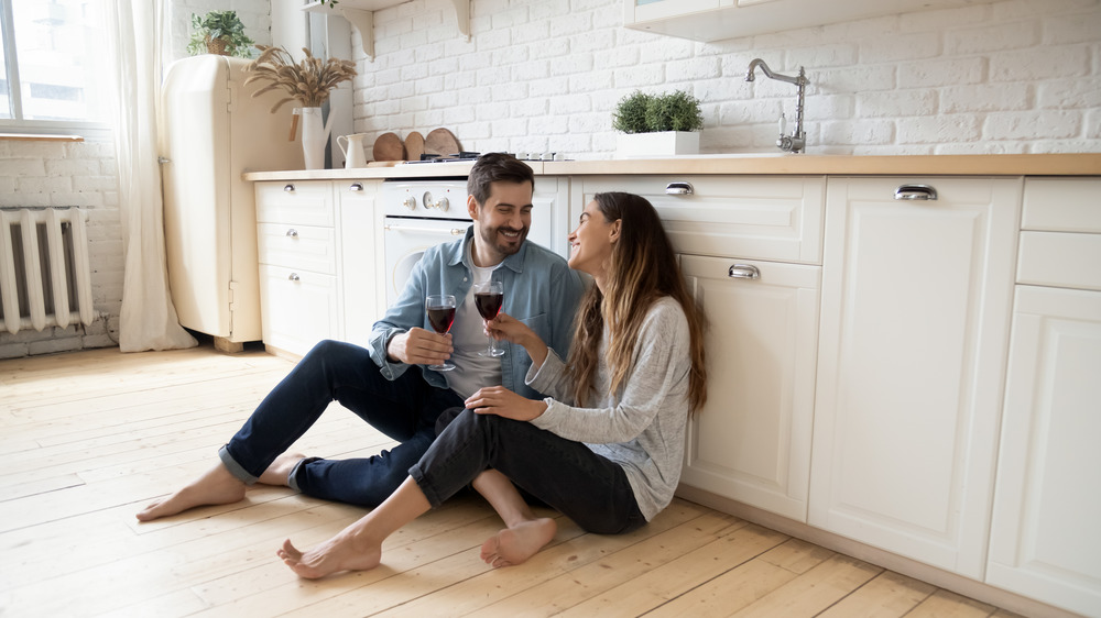 couple sitting on floor drinking wine