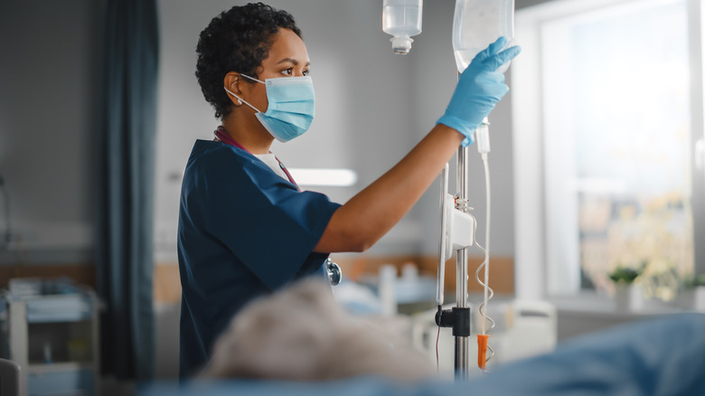 nurse working with patient on hospital bed