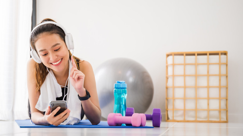 young girl at the gym distracted by her phone 