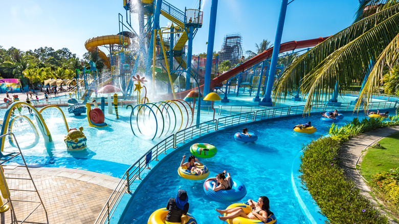 Water park with water rides and swimmers floating on tubes