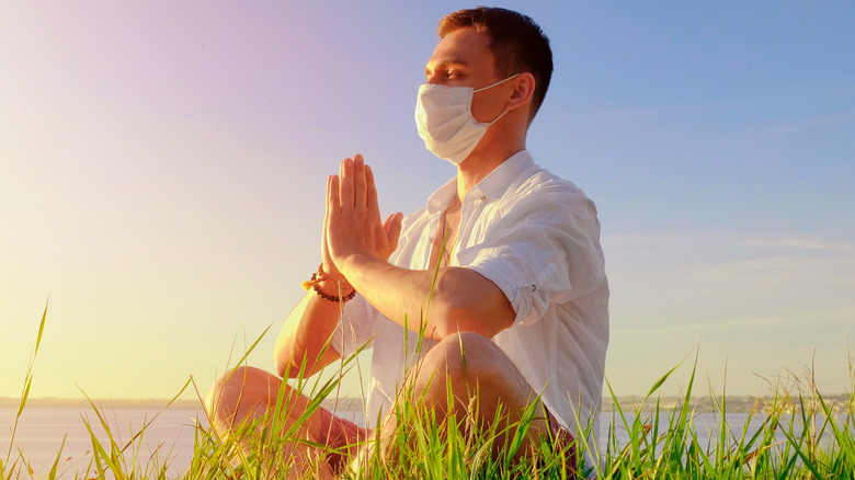 man wearing mask while meditating