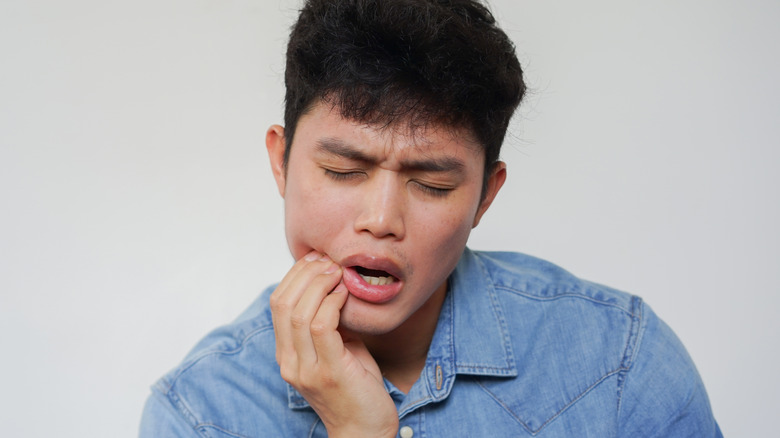 Man holding jaw in pain